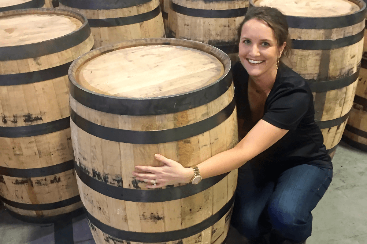 Allisa Henley with barrels at the AJ Bond Distillery.